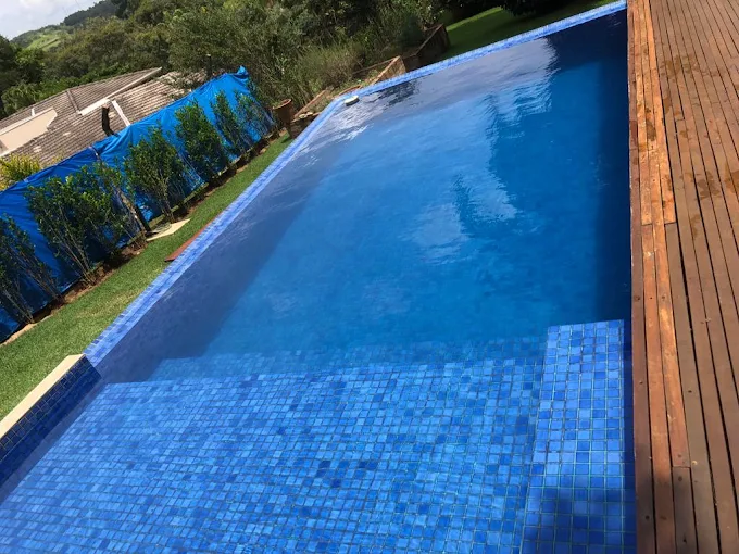 Piscina de borda infinita com deck de madeira